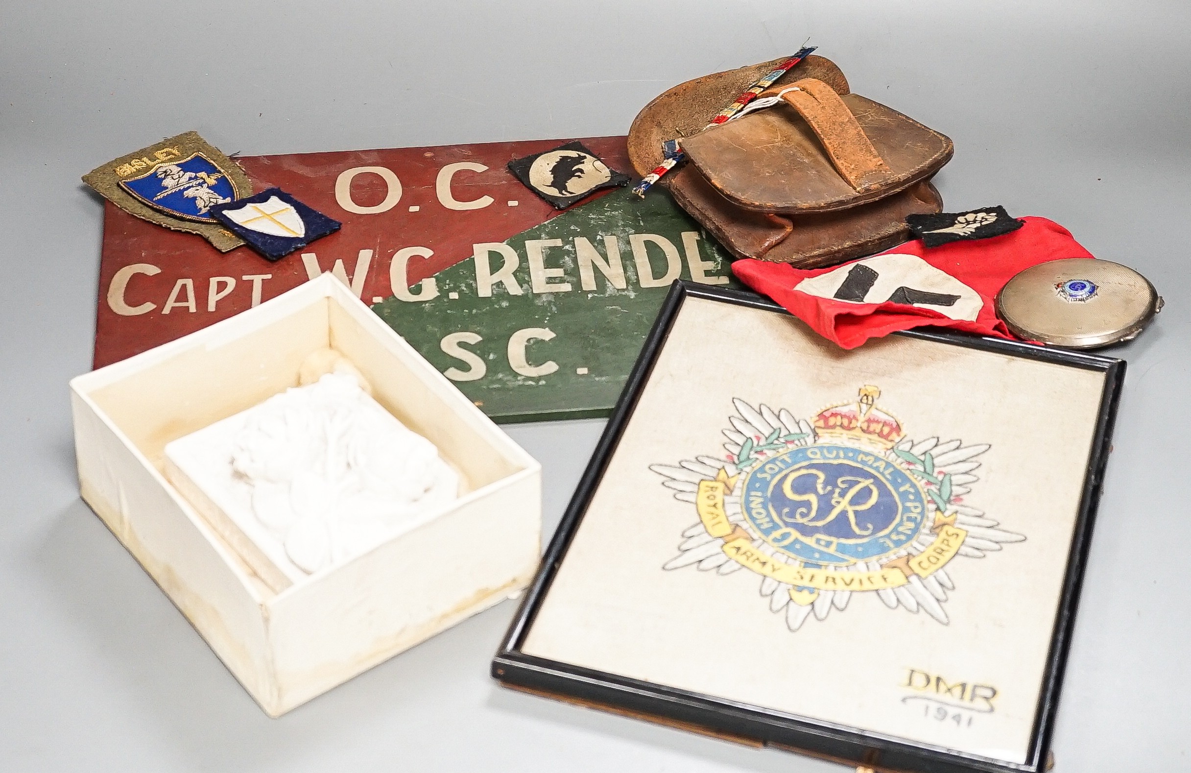 A group of WWI and WWII militaria badges, buttons, two swagger sticks, an armband and a World War I German POW inscribed plaster ornament, longest swagger stick 70 cms long.